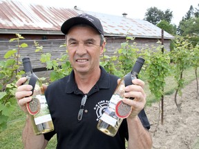 Mike Korpan, winemaker with Early Acres Estate Winery, shows off two prize-winning bottles, 'Roadside View' and 'Just Chillin'', in the All Canadian Wine Championships. The business is located on Pioneer Line just outside of Chatham. TREVOR TERFLOTH trevor.terfloth@sunmedia.ca