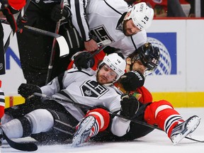 Chicago Blackhawks’ Michal Handsuz (C) loses his helmet while falling with Los Angeles Kings’ Mike Richards (L) and Dustin Penner in the first period during Game 1 of their NHL Western Conference final hockey playoff game in Chicago, Illinois, June 1, 2013. 
REUTERS/Jeff Haynes