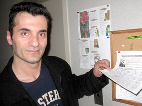 Muhamet Bajraktari looks at the signatures that have already been collected on a petition, placed on a bulletin board in the apartment building he lives in, which calls on the Canadian government to reverse a deportation order against him and his wife Ganimete Berisha, as well as their four-year-old daughter Eliza Bajrakarti, who was born in Chatham. ELLWOOD SHREVE/ THE CHATHAM DAILY NEWS/ QMI AGENC