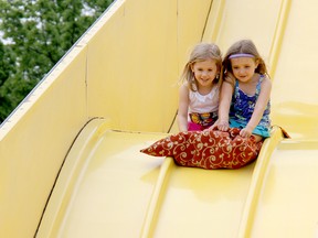 Four-year-old Chloe Vadovic, left, and her twin sister, Karissa, go for a slide at the Kinsmen Fair on Sunday. TREVOR TERFLOTH/ THE CHATHAM DAILY NEWS/ QMI AGENCY