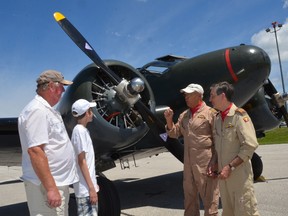 Al Shaw, left, and his grandson Jackson Wit, listen as pilots Leon Evans and Rick Rickards, right, tell them about the Beech 18 aircraft they just took a flight in at the Wings and Wheel event at the Owen Sound Billy Bishop Regional Airport on Sunday. The plane, from the Canadian Warplane Heritage Museum, was offering up flights during Sunday's event, which attracted hundreds of classic vehicles and dozens of aircraft. (Rob Gowan The Sun Times)