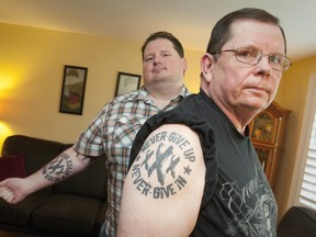 Retired London Police Staff Sgt. Rick Izzard, right, shows off the matching tattoo he got with his son Ryan, left, when the younger Izzard kicked his prescription drug addiction with the help of methadone, which he was doctor-prescribed after a hockey injury in his teens. (CRAIG GLOVER, The London Free Press)