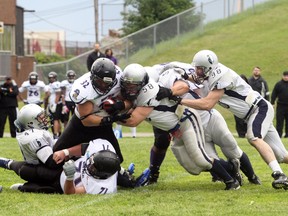 Sudbury Spartans defenders, including Joe Kerr (58) and Bruno Rocca (98) try to hold back Montreal Transit running back Samuel Fournier during Northern Football Conference action at Queen's Athletic Field last season. Ben Leeson/The Sudbury Star/QMI Agency