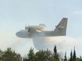 A Ministry of Natural Resources CL-415 waterbomber drops a load over a wild fire.
Miner and News file photo