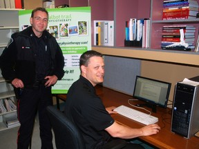 St. Thomas Police Const. Jason Geddes, left, and Talbot Trail physiotherapist Chris Streib view an email on a computer at the Talbot Trail clinic in St. Thomas. The clinic was recently targetted in a credit card scam. (Ben Forrest, Times-Journal)
