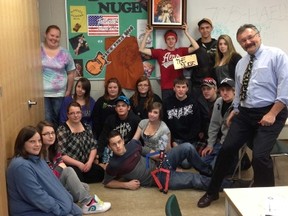 Steve Todoroff, Grade 11/12 workplace math teacher at Almaguin Highlands, and his students pose for a picture in front of the Ted Nugent shrine. The rocker has been communicating with the class and has signed T-shirts, hats and posters. Nugent is encouraging students not to drink, do drugs or follow peer pressure.