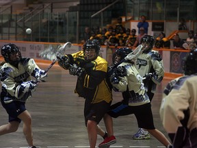 A Sherwood Park Titans Junior ladies lacrosse forward gets a shot off while being hit from behind in a 13-3 win over the Drillers at the Arena earlier this season. After years of domination, the Titans are the only team in a new division this season. Photo by Shane Jones/Sherwood Park News/QMI Agency
