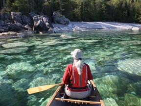 Ruth Fletcher takes a moment from paddling to enjoy the view of rocks along the Lake Superior shoreline.