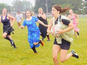 MONTE SONNENBERG Simcoe Reformer
Sarah Stewart of Simcoe hikes up her dress for a run upfield during a spirited game of prom dress rugby at Waterford District High School on Monday. The game was a lark for the girls who competed this spring in the local high school rugby loop.