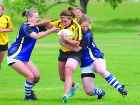 Grande Prairie Sirens’ Megan Oldford tries to break free of a tackle by two Edmonton Pirates as the teams met in Edmonton Rugby Union play  Saturday at the Peace Wapiti Academy field. The Sirens won 65-5 with Oldford named game MVP. (Diana Rinne/Daily Herald-Tribune)