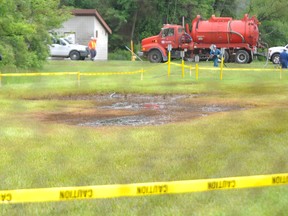 Industrial officials investigate a crude oil spill just south of Enbridge's property on Indian Road Tuesday around 10:30 a.m. The oil spill occurred in a grassy area where pipelines from Enbridge, Imperial Oil and Plains Midstream are located. TYLER KULA/ THE OBSERVER/ QMI AGENCY