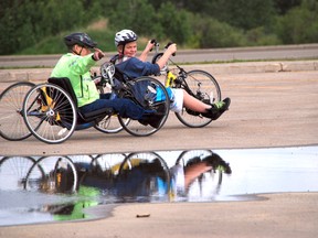 Paraplegic Dale Williams teaches 14-year-old Dylan Lawrance how to manoeuvre a handcycle during the volunteer training session at the Centre 2000 parking lot Saturday, June 8, 2013.  JOCELYN TURNER/DAILY HERALD-TRIBUNE