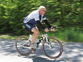 Denis Morel, a corrections officer who has competed in 28 Ironman triathlons around the world, cycles along a country road north of Kingston. (Michael Lea/The Whig-Standard)