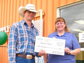 Arnelda Fell, customer sales and service manager for the Fairview UFA Farm and Ranch Supply store (left), presented a cheque for $500 to Riley Buker, president of the Cleardale Riders