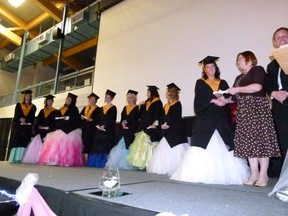 Sarah Wade accepts her scroll from Peace River School Division deputy superintendent Karen Penney with the rest of the graduates to the left.