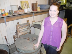 Jodie Keene, Teeterville Pioneer Museum's summer coordinator, shows off the museum's collection of washing machines on opening day of the museum in May. (SARAH DOKTOR Delhi News-Record)
