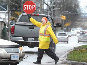 Crossing guard Bev Hider is surrounded by traffic during her after-school shift on Huron and Huntingdon streets. (SCOTT WISHART, The Beacon Herald)