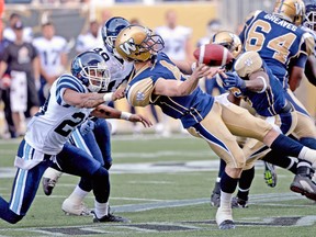 Blue Bombers quarterback Buck Pierce barely gets the ball away before getting taken down by Toronto Argonauts’ Bryan Payton during Wednesday night’s pre-season game in Winnipeg. (REUTERS)