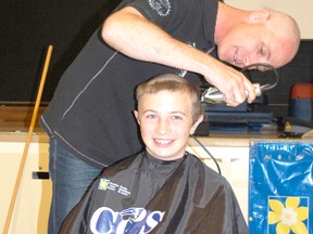 Students and adults alike shaved their heads for Cops for Cancer at Ripley-Huron Community School on June 6, 2013.  Grade 8 student Riley Kirkpatrick gets his head shaved by his Dad Mike. (ALANNA RICE/KINCARDINE NEWS)