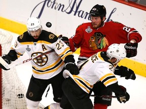 Bruins forward Chris Kelly (left), defenceman Andrew Ference battle for the puck against Blackhawks forward Bryan Bickell during Game 1 of the Stanley Cup final at the United Center in Chicago, June 12, 2013. (JIM YOUNG/Reuters)