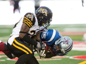 A Ticats defender and an Als receiver play crash and smash Thursday night on the field at Molson Stadium in Montreal. (QMI AGENCY/PHOTO)