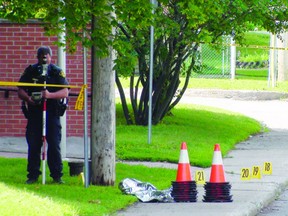 DANIELLE BELL QMI Agency
Police evidence markers dot Russell St. in Arnprior Thursday, June 13, 2013 where a 21-year-old man was knifed to death on Wednesday, June 12, 2013.