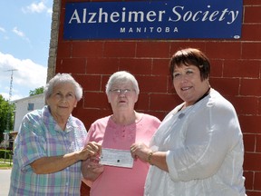 Evelyn Smith, left, and Elaine Cairns present a donation of $1,000 on behalf of the Kozy Korner Seniors to Karen Lambert of the Alzheimer Society of Manitoba. The money is for the Memory Walk the society hosted last week in Portage la Prairie. (CLARISE KLASSEN/PORTAGE DAILY GRAPHIC/QMI AGENCY)