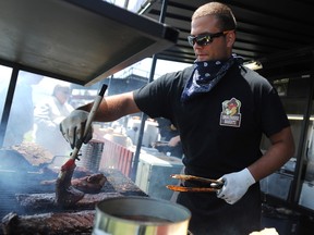 Ribber Nathan Diloreto coats a rack of ribs with sauce at the Smokehouse Bandits kiosk at Sarnia Ribfest Friday. The London, Ont.-based company is one of seven ribbers at the Sarnia Kinsmen event, this year at Hiawatha Horse Park. (TYLER KULA/ THE OBSERVER/ QMI AGENCY)