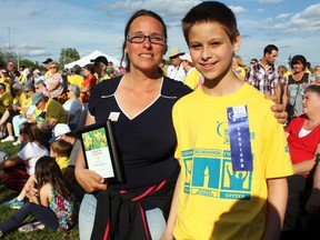 Hundreds of people gathered at the O’Gorman High School athletic track for Timmins’ largest Canadian Cancer Society Relay for Life to date. Close to 100 cancer survivors were part of the group, including Nathan Hettinger, right, who was diagnosed with cancer at the age of three. His mother Tammy, left, was recognized during the opening ceremonies on Friday for her invaluable work as a caretaker.