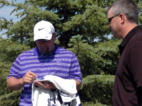 Former Toronto Maple Leafs captain Wendel Clark, left, signs a jersey for Craig Boucher Saturday at a charity golf tournament in Port Stanley. The tournament aims to raise $10,000 for Locke's Public School and SickKids Hospital in Toronto. Retired NHLer Brad May also attended the event.(Ben Forrest, Times-Journal)