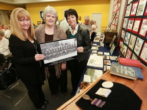 Lori Oschefski, Gloria Phillips and Sandra Joyce hold up a photo of an early group of Barnardo Boys shipped to Canada in 1882. The three women were presenters at the Owen Sound and North Grey Union Library in Owen Sound on Saturday, June 15, 2013 for a seminar on the history of the British Home Children.  (JAMES MASTERS/QMI Agency/The Sun Times)