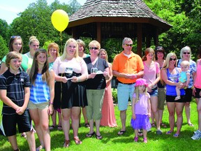 SEAN CHASE   Surrounded by family and friends, Alexis Benoit joins her mother, Amy (third and fourth from the left) as they release monarch butterflies during a ceremony of remembrance at Pansy Patch Park on Saturday. Amy Benoit was honouring the memory of her son, Cody.