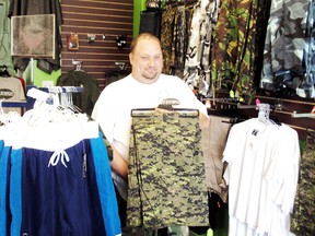Mike Makarich displays some of the camouflage clothing that he carries in M.P. Surplus, his Fourth Street store in Chatham, On. After working out of his home for six years Makarich decided to open his own store front and says business is good. (BOB BOUGHNER, Chatham Daily News)