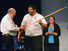 Valley Heights teacher Dave Zakel presents a commemorative paddle to retiring rowing and cross-country coach Larry Wiebe at the school's athletic awards banquet last Wednesday. CHRIS ABBOTT/TILLSONBURG NEWS