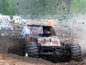 Mud is sprayed into the air from Dean Wedler as he plows through a mud pit at the Mudfest in Evergreen Park, Sunday, June 16, 2013. This is the first time that Mudfest, which used to be called the Tire Pro Mug Bog, has been held at Evergreen Park. Previously the event was held near the Grande Prairie Airport. AARON HINKS/HERALD-TRIBUNE