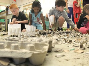 Debris covers the floor as Grade 1 students at Centennial Public School work on a decorative plant project on Friday. (Michael Lea The Whig-Standard)