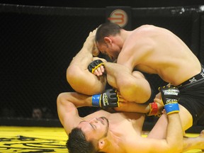 Mike Karkula of Toronto (bottom) and Brad Cardinal of Lethbridge grapple at the inaugural XCessive Force MMA Championships, at Evergreen Park, just south of Grande Prairie, Alberta, Saturday, March 30, 2013. Karkula won the main event fight via rear naked choke hold. Cardinal tapped out with one second remaining in the five-minute opening round. Upcoming MMA events in Grande Prairie might be put on hold due to changes in the criminal code. (DHT file photo)