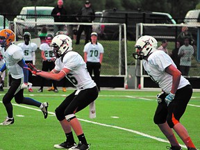 Salisbury Sabres quarterback Reggie Schoeppe is flanked by teammate Tevin McCarty during the recent Border Bowl provincial battle in Kelowna, B.C. Photo supplied
