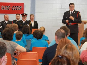 Timmins Police Service Const. David Ainsworth addresses the crowd gathered for a recent DARE (Drug Abuse Resistance Education) program at  École catholique Sacré Coeur. The students had just finished the nine-week DARE program, which gives them the tools to think and act in tough situations, to overcome peer pressure and make positive life decisions.