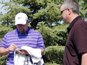 Former Toronto Maple Leafs captain Wendel Clark, left, signs a jersey for Craig Boucher at a charity golf tournament Saturday in Port Stanley. The tournament aims to raise $10,000 for Locke's Public School and SickKids Hospital in Toronto. Retired NHLer Brad May also attended the event. (Ben Forrest, Times-Journal)
