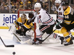 Bruins goaltender Tuukka Rask keeps his eyes on the puck after making a save on Blackhawks forward Jonathan Toews (centre) during Game 3 of the Stanley Cup final at TD Garden in Boston, June 17, 2013. (WINSLOW TOWNSON/Reuters)