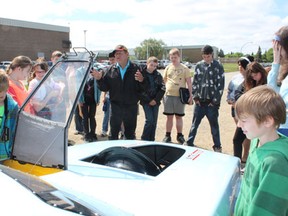 Kevin Therres of Prairieland Motorsports talks with MUCC students outside the school on Wednesday, June 12.