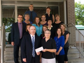 Brian Mooney of Portage Mutual Insurance presents a cheque for $2,857.26 to Nancy Matthews, co-chair of the Central Plains Challenge Walk and Run, Tuesday, as members of the Mutual's walking club stand behind. (ROBIN DUDGEON/PORTAGE DAILY GRAPHIC/QMI AGENCY)