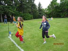 Runners cross the finish line during the Elementary Cross Country Meet at Spruce Haven Park on Monday, June 10.