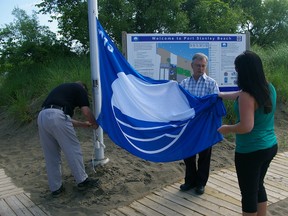 Central Elgin Deputy Mayor David Marr, centre, gets Blue Flag ready to fly Tuesday, June 18, 2013 in Port Stanley at Main Beach, with Tim McKenna, left, Central Elgin environmental and community services manager, and Chandra Dougall, right, municipal management intern. (Eric Bunnell, Times-Journal)