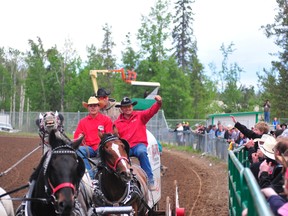 The champion of the 2013 Grande Prairie Stompede Rick Fraser throws a fist into the air as a fan tries to reach him Sunday, June 2, 2013. Fraser won the World Professional Chuckwagon Association Dash for Cash with a time of 1:17.81. This past weekend Fraser added another title win for the season at the Medicine Hat Exhibition & Stampede. (AARON HINKS/Daily Herald-Tribune)