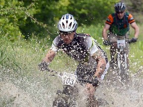 James Feeney rides through a large puddle during The Wild Ride fundraising mountain bike race at Wildwood Conservation Area near St. Marys on Saturday. The third annual event raised more than $18,000 for The Lung Association. (SCOTT WISHART The Beacon Herald)