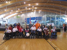 The Fort McMurray firefigherspose with the Canadian powerchair football team. The FMFD raised $20,000 for wheelchair basketball players.  SUPPLIED PHOTO
