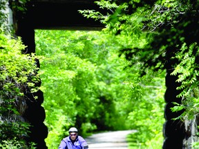 Sandy McKenzie cycles under the railway overpass on the Brock Trail Tuesday. The Brockville cycling advisory committee is urging city councillors not to consider the Brock Trail expansion as a "nice-to-have," but an important part of the city's transportation network. THOMAS LEE The Recorder and Times