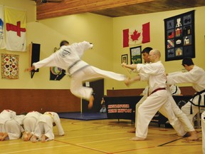 Jocel Madriaga demostrates a flying side kick for his second degree blackbelt.